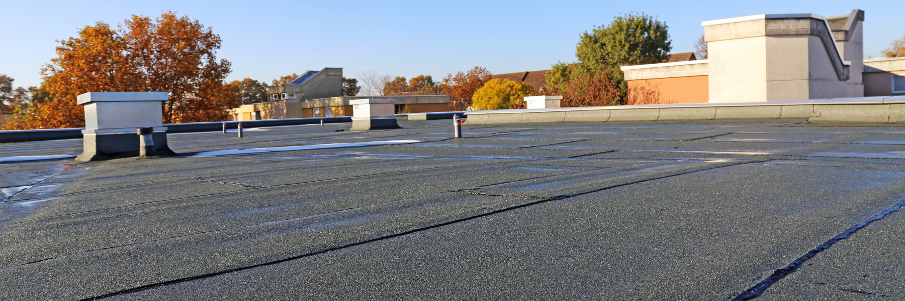 Low-slope commercial roof showing surface wear and potential early failure indicators